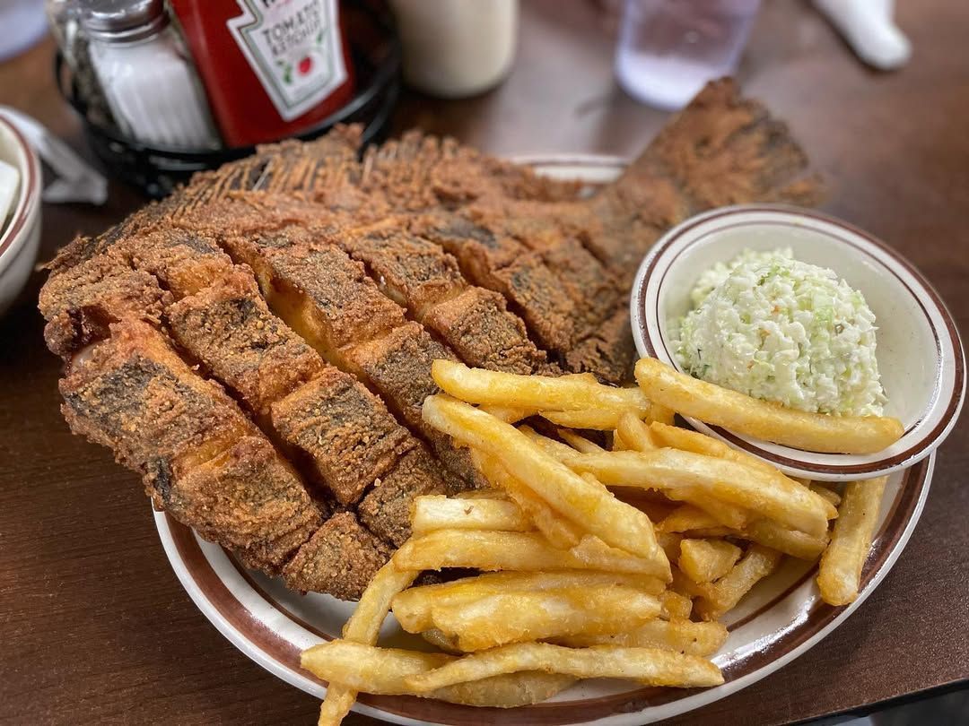 Golden fried fish fillet with crispy French fries and creamy coleslaw at Hoskins Restaurant in North Myrtle Beach, a local favorite for seafood lovers.