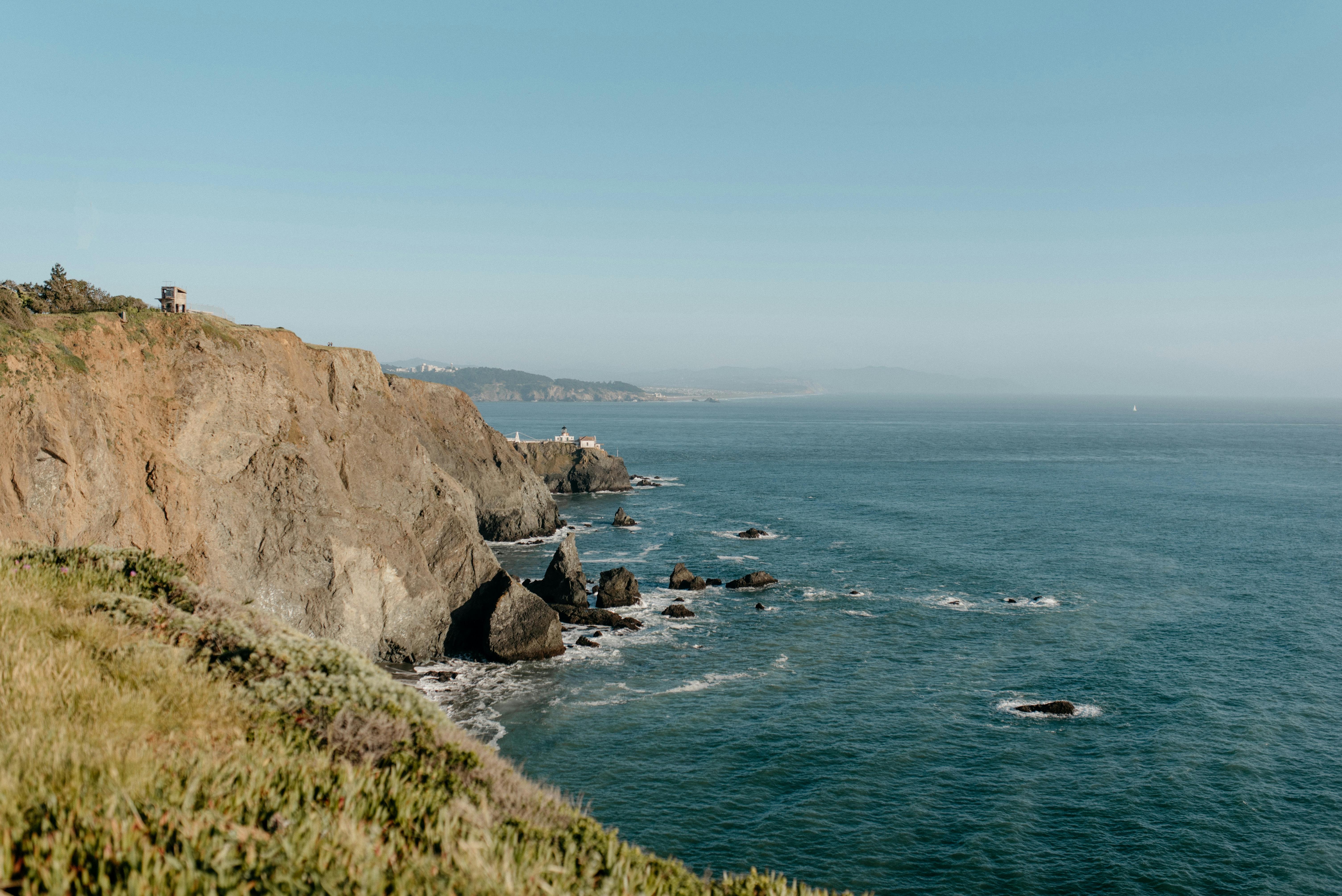 Rugged coastal cliffs rise above the blue Pacific Ocean along a scenic hiking trail near the San Diego coastline. This breathtaking view shows the dramatic landscapes and ocean vistas hikers can enjoy along San Diego’s coastal trails.