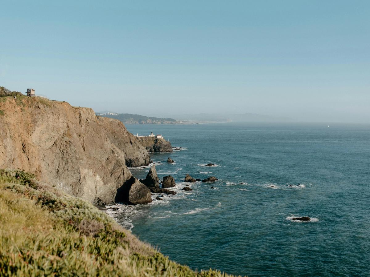 Rugged coastal cliffs rise above the blue Pacific Ocean along a scenic hiking trail near the San Diego coastline. This breathtaking view shows the dramatic landscapes and ocean vistas hikers can enjoy along San Diego’s coastal trails.
