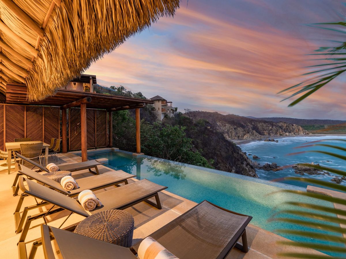 Scenic cliffside view in Huatulco with an infinity pool and ocean waves below, offering a stunning farewell to your beach getaway. A dreamy spot to reflect on your trip.