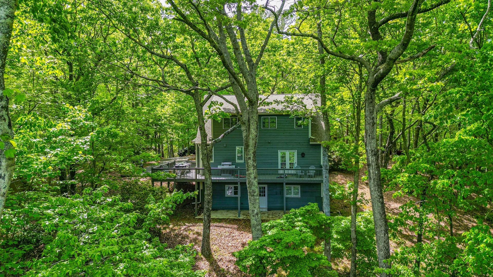 This charming mountain home sits tucked among lush green trees in the heart of Big Canoe, Georgia. With wraparound decks and peaceful forest views, it’s the perfect escape for nature lovers seeking tranquility.