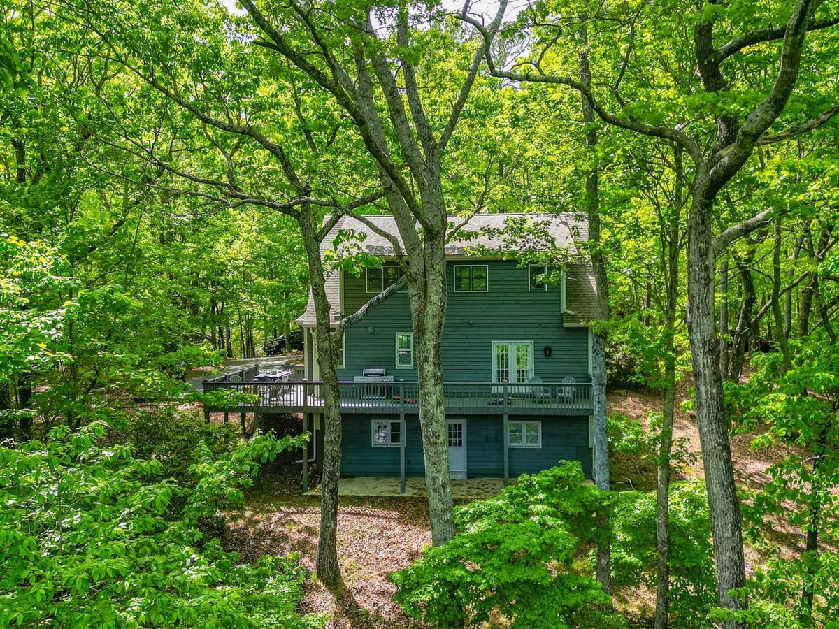 This charming mountain home sits tucked among lush green trees in the heart of Big Canoe, Georgia. With wraparound decks and peaceful forest views, it’s the perfect escape for nature lovers seeking tranquility.
