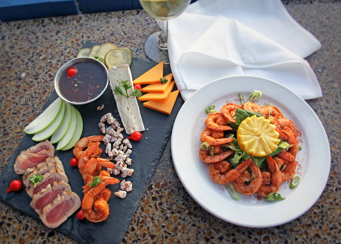 A coastal platter of shrimp, cheese, and seared tuna served with a glass of white wine at South Beach Grill. The elegant seafood presentation reflects the restaurant’s fresh and flavorful approach to waterfront dining.