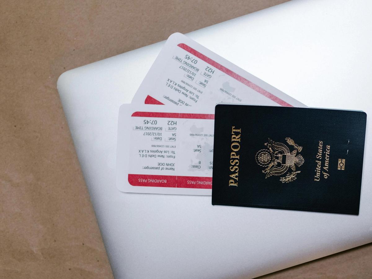 A U.S. passport and boarding passes placed on a laptop, ready for international travel to Huatulco, Mexico. This image highlights the importance of having your travel documents prepared before your trip.
