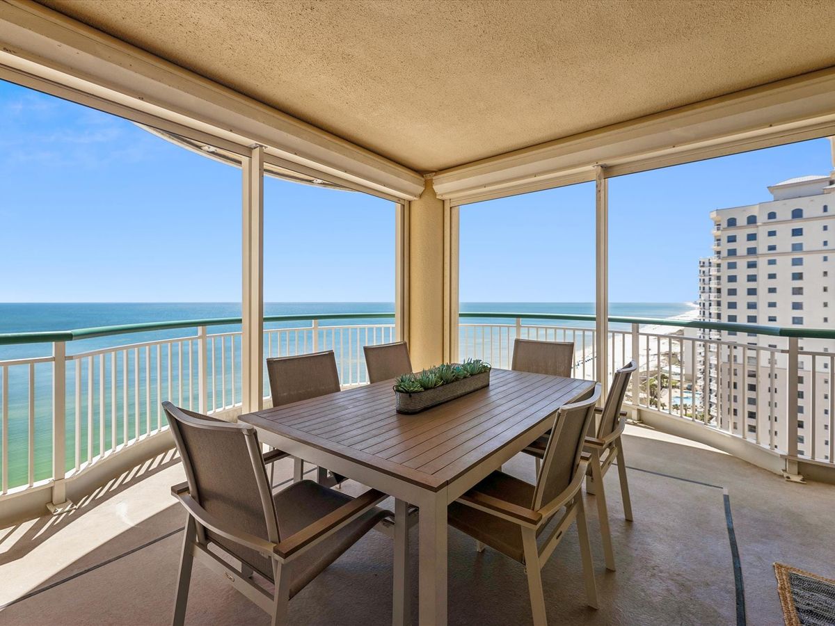This spacious balcony dining area offers endless views of the emerald Gulf waters, ideal for outdoor meals with ocean breezes. The modern furniture and open design make it easy to relax and enjoy the coastal beauty.