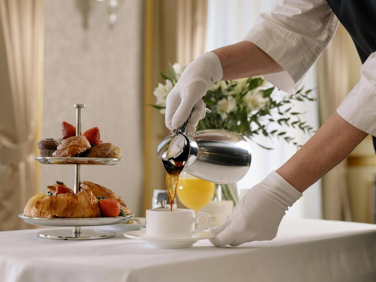 A bright, cozy hotel room with a modern layout, neutral tones, and a neatly made bed. The simplicity and clean design highlight the comfort and predictability guests enjoy.