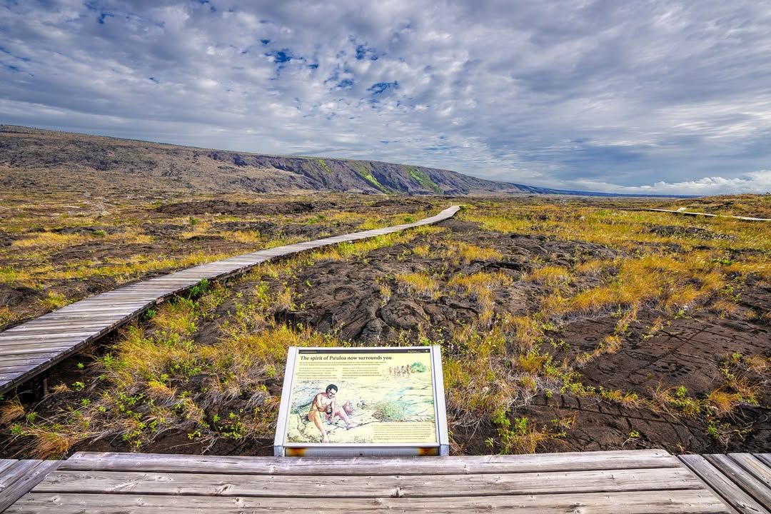 A wooden boardwalk winds across a vast lava field at Puʻuloa Petroglyphs, guiding visitors through one of Hawaii’s most sacred historic sites. This ancient area features hundreds of carvings that tell the stories of native Hawaiian culture.