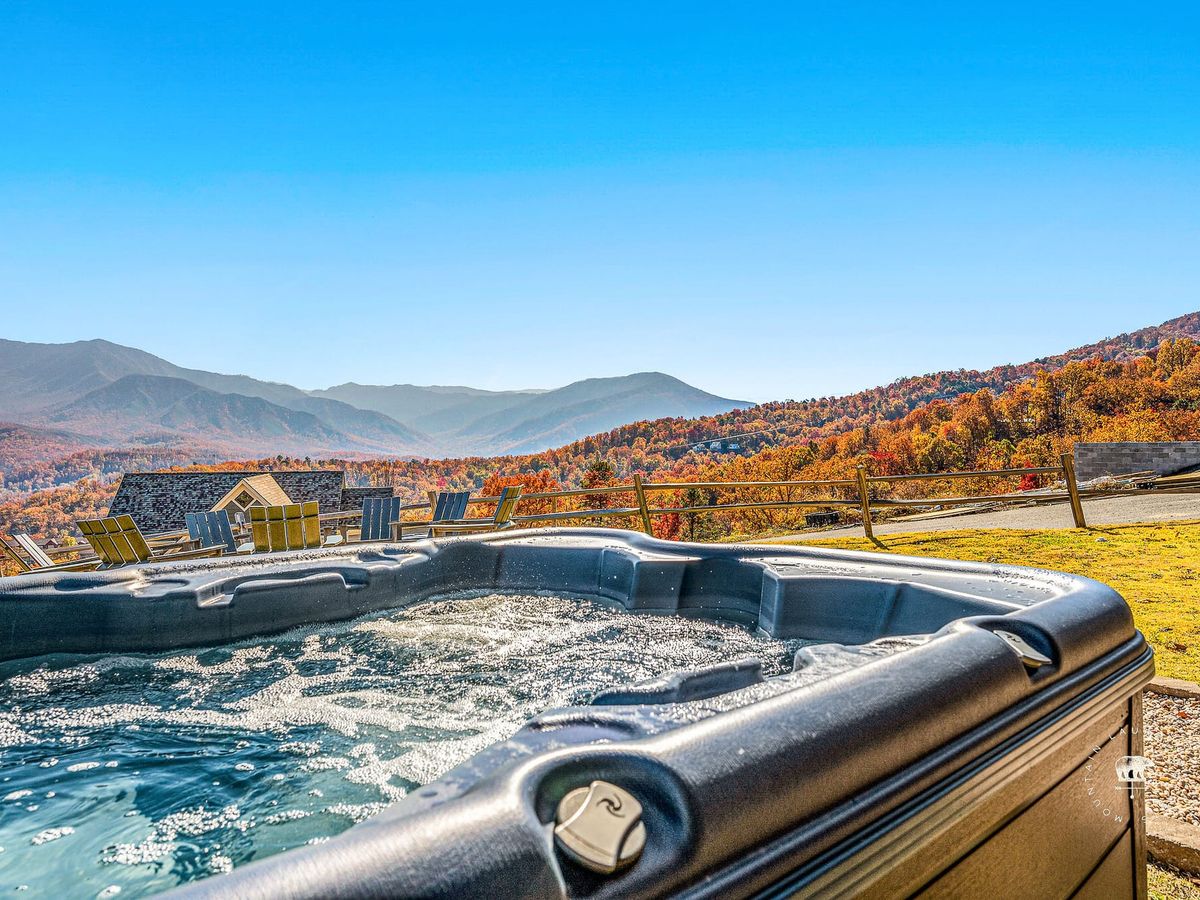 A bubbling hot tub overlooks sweeping mountain views and golden autumn colors. This spacious cabin offers comfort, adventure, and relaxation in Tennessee’s Smoky Mountains.
