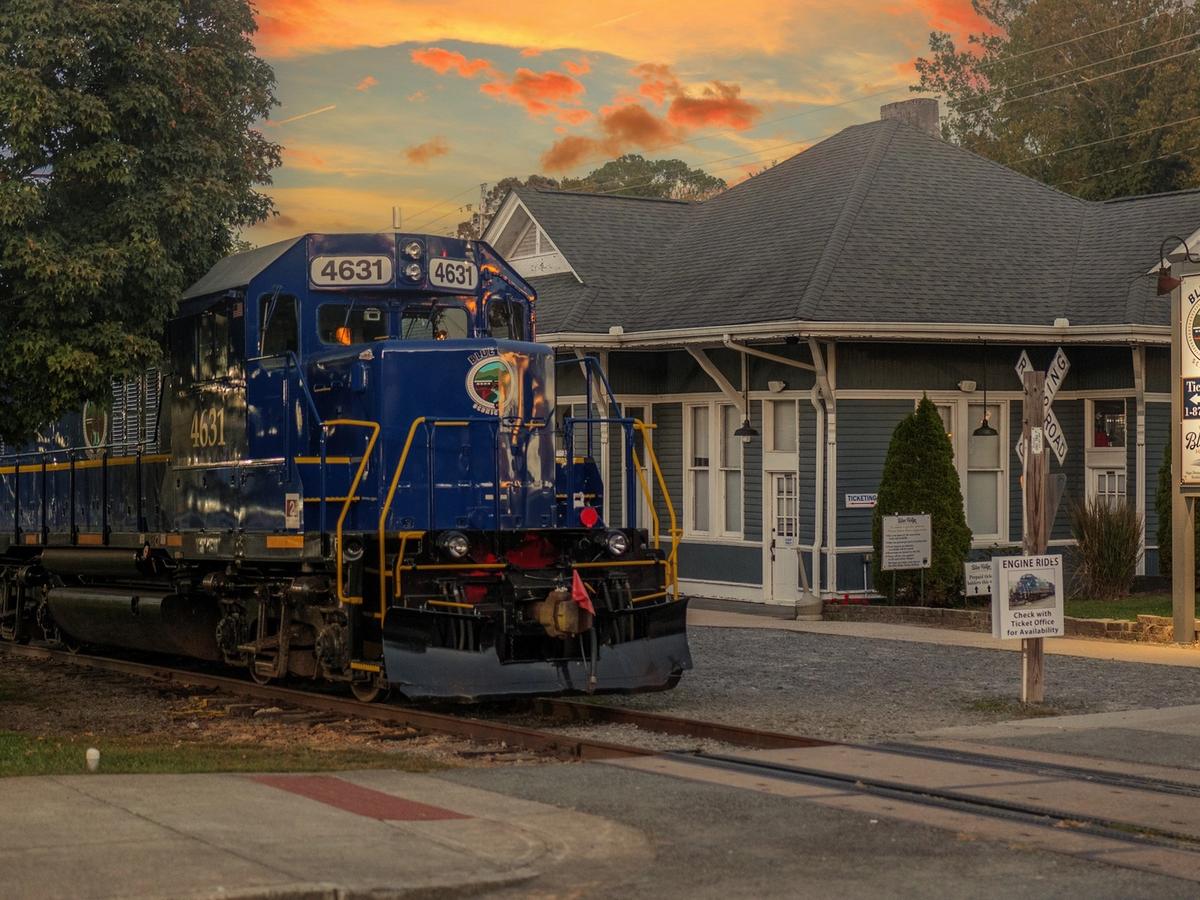 The Blue Ridge Scenic Railway train sits at the historic depot in downtown Blue Ridge during golden hour. This popular attraction offers scenic train rides through the North Georgia mountains, especially known for fall foliage and seasonal trips.