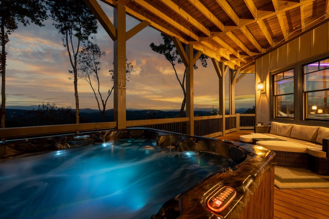 A stunning multi-level mountain lodge surrounded by tall trees in Blue Ridge, Georgia. Expansive wooden decks offer forest views and cozy outdoor spaces perfect for gathering with family and friends.