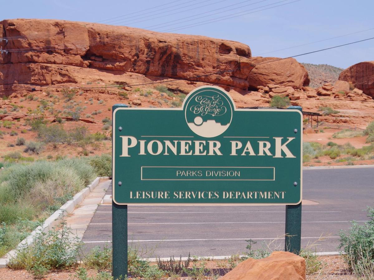 The sign for Pioneer Park marks the entrance to a red rock playground in St. George, Utah, known for climbing, hiking, and stunning views.