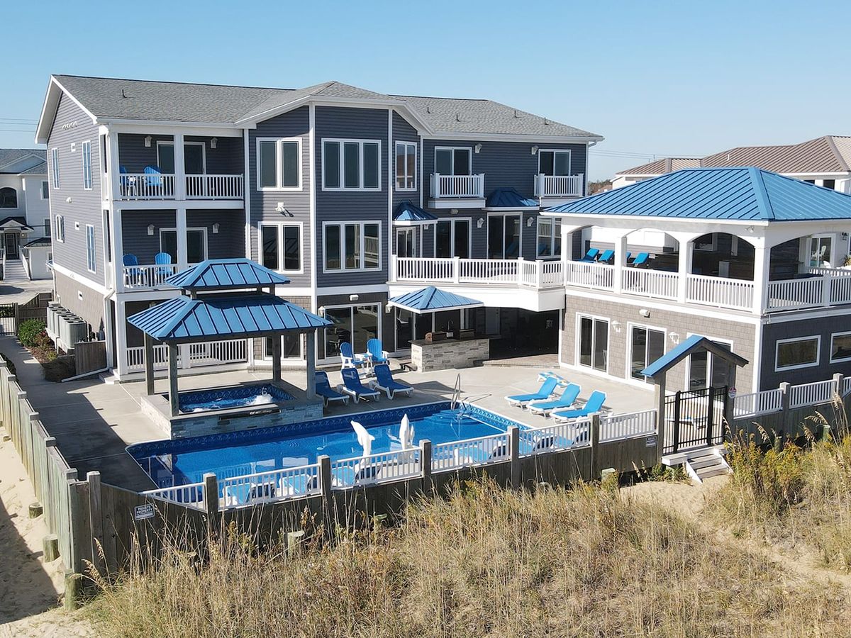 Massive luxury rental with a resort-style pool, shaded pavilions, and multiple balconies overlooking the beach. Tailored for weddings, events, or large family gatherings.