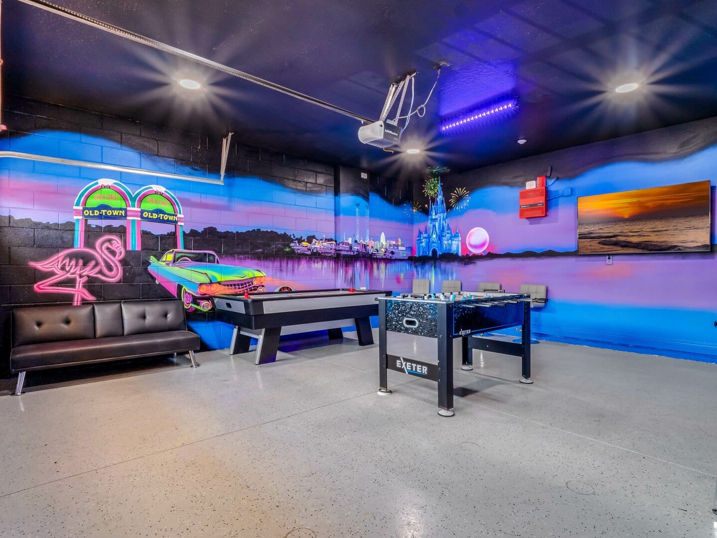 Game room with vibrant, retro colors on the walls and fosball and air hocket table in the middle