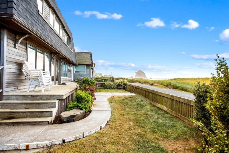 A private beachfront yard with a paved walkway leading directly toward the shoreline and sand dunes. This outdoor space makes beach access easy while offering a peaceful spot to enjoy the fresh coastal air.