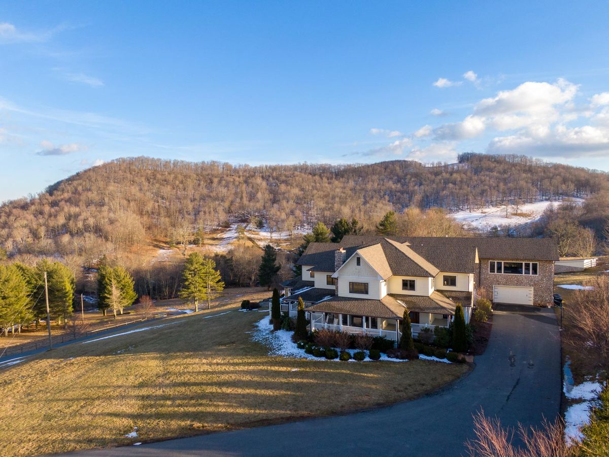 Exterior of large vacation rental in north carolina with light snow at the bottom surrounded by mountains
