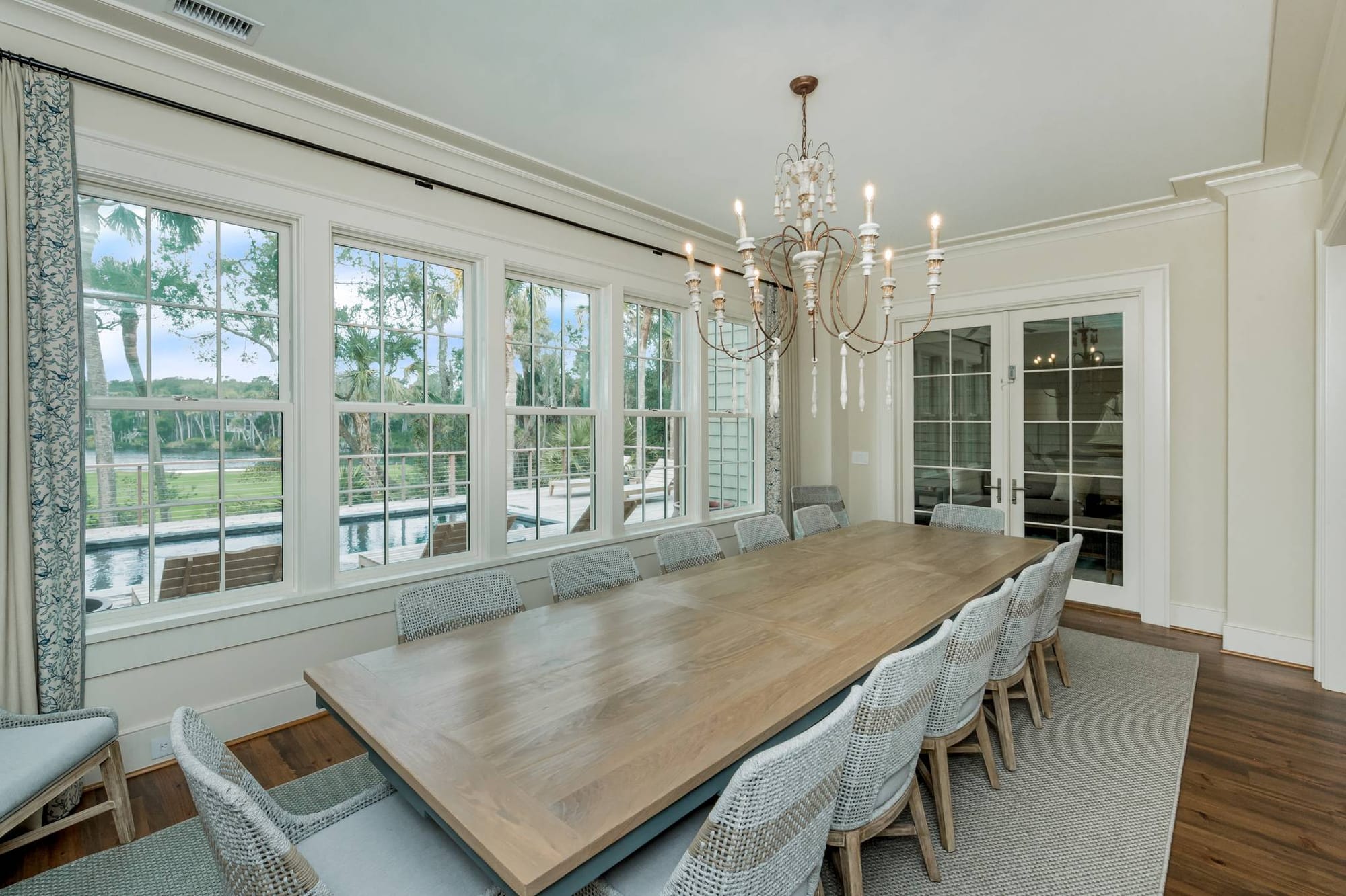 This elegant dining room offers a long wooden table, soft lighting, and wide windows with peaceful outdoor views. It’s an ideal space for family dinners, celebrations, or slow meals after a day exploring the area.
