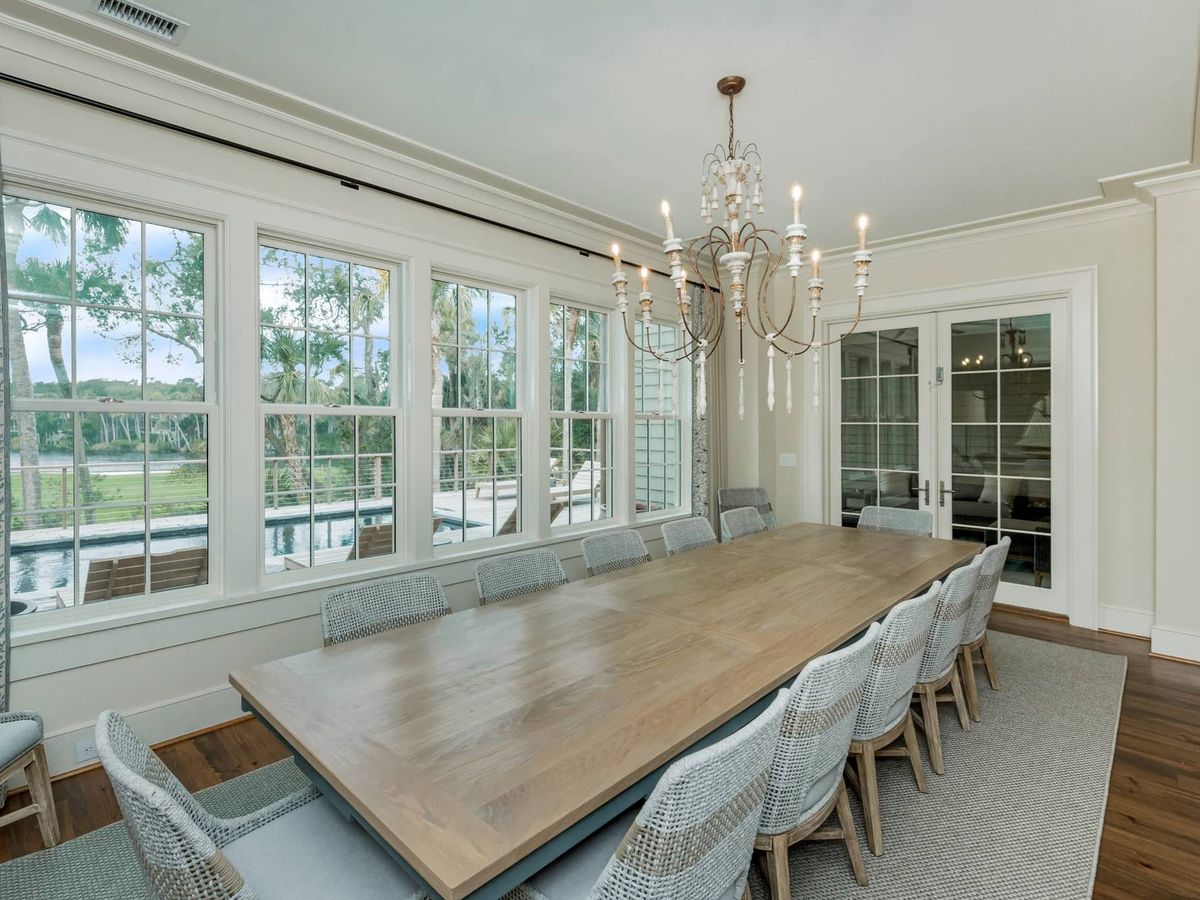 This elegant dining room offers a long wooden table, soft lighting, and wide windows with peaceful outdoor views. It’s an ideal space for family dinners, celebrations, or slow meals after a day exploring the area.