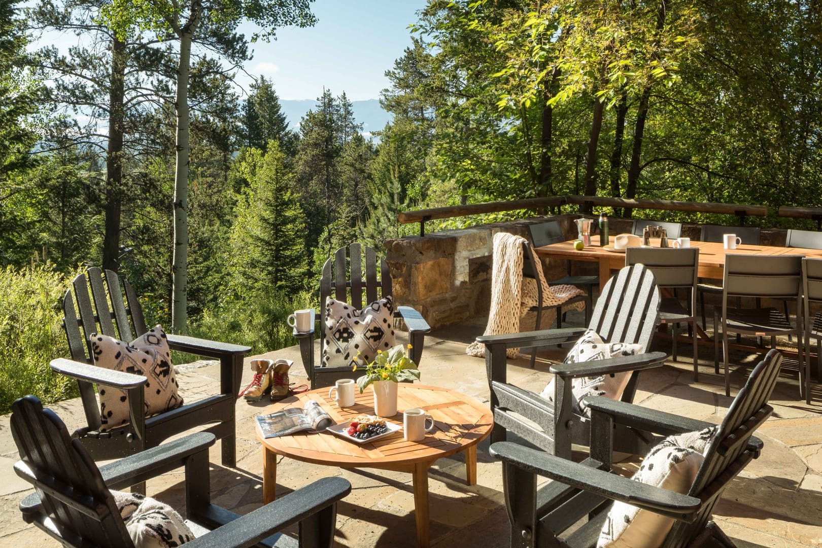 Outdoor patio area with outdoor fining and brunch on table surrounded by trees and mountains 
