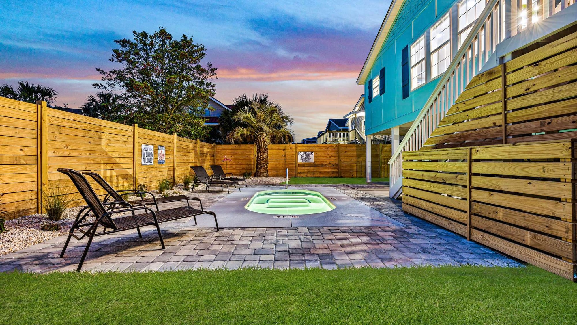 This private pool retreat offers the perfect mix of fun and privacy with tropical palms, modern loungers, and a cozy fenced yard. The glowing pool invites guests to enjoy warm Carolina evenings under the stars.