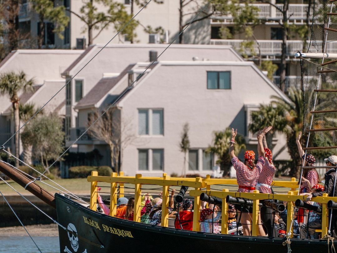 ids dressed as pirates cheer aboard the Black Sparrow ship on Hilton Head Island. The Pirates of Hilton Head cruise offers a fun family adventure filled with treasure hunts, water battles, and lots of laughter.