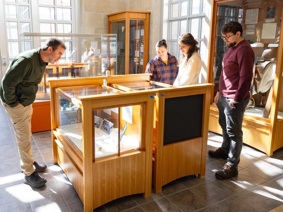 Visitors explore a local museum exhibit in downtown Cody, Wyoming, with glass displays and Western history artifacts. Downtown offers a mix of culture, dining, and historic experiences.