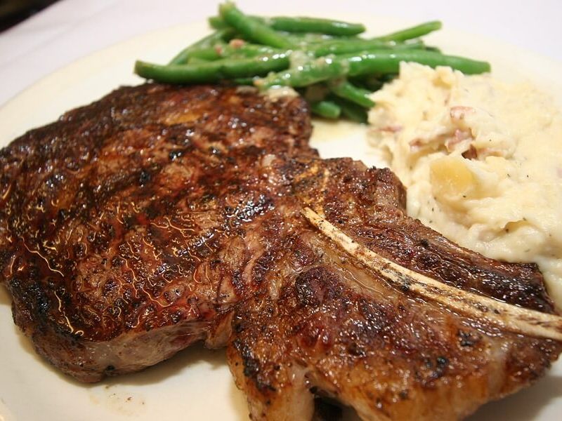 A sizzling grilled steak is served with creamy mashed potatoes and crisp green beans at JK’s Restaurant. This hearty plate is all about classic comfort food done right