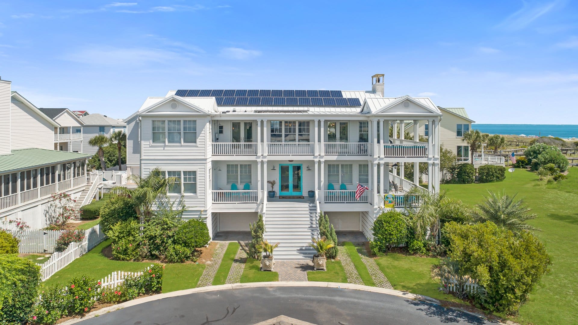 A bright white beach house with solar panels sits just steps from the ocean on Tybee Island. With wide porches and coastal décor, it blends eco-friendly design with classic Southern beach charm.