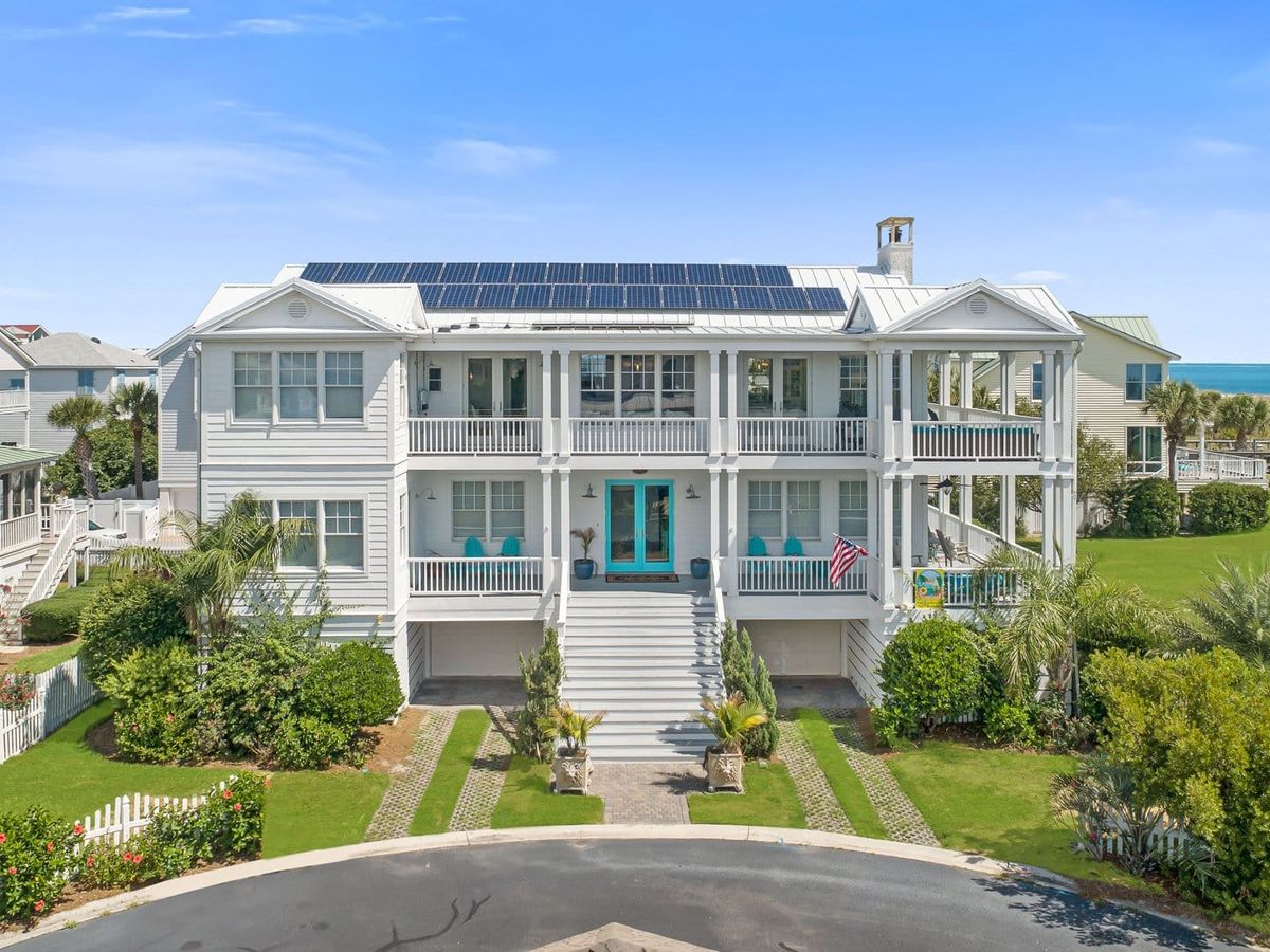 A bright white beach house with solar panels sits just steps from the ocean on Tybee Island. With wide porches and coastal décor, it blends eco-friendly design with classic Southern beach charm.