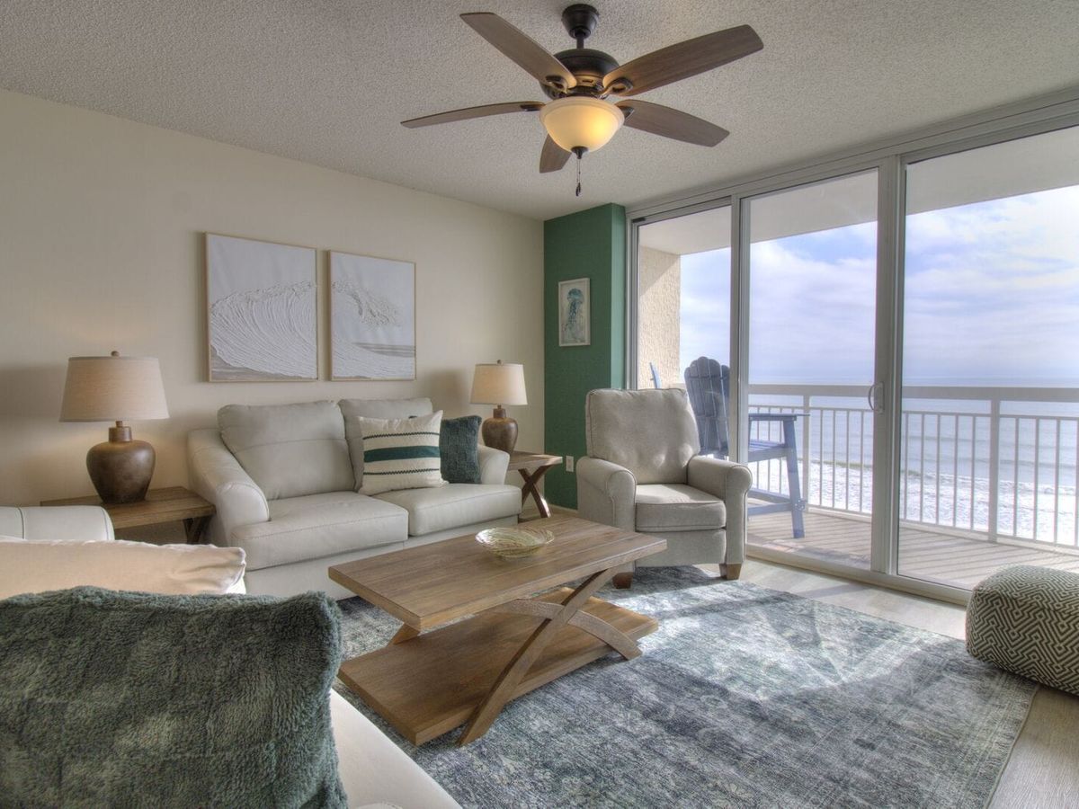Relaxed beach living room with calming green walls, cozy recliners, and wide ocean views from every seat. It’s a great space to gather for movie nights or lazy afternoons.