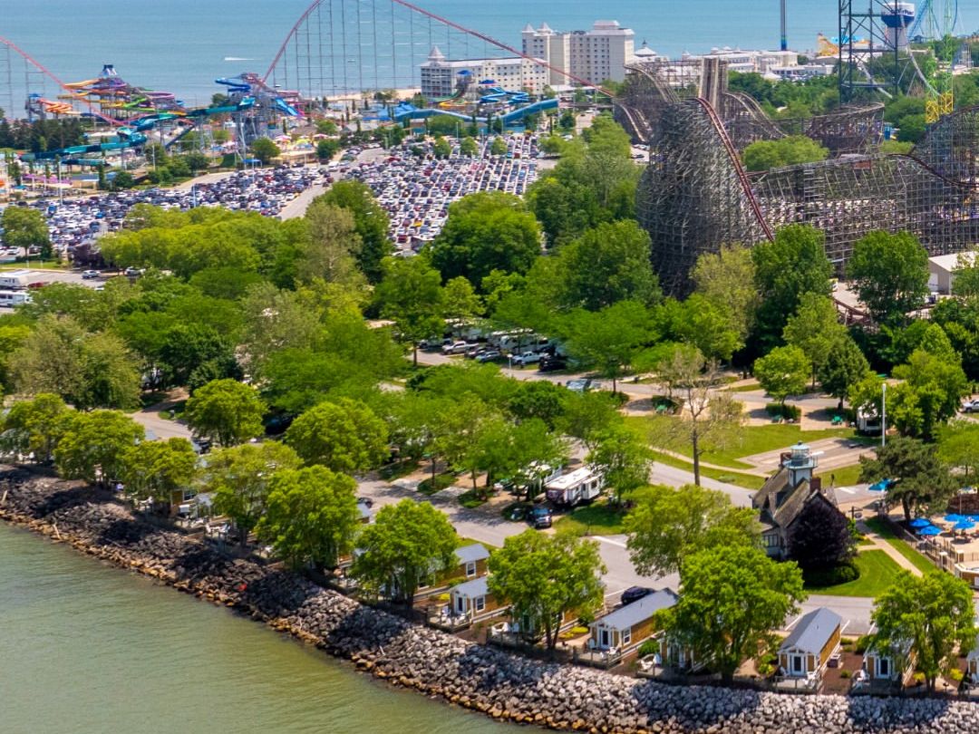 Panoramic view of Cedar Point with towering roller coasters and sandy beachfront along Lake Erie. One of the most iconic amusement parks in the U.S.