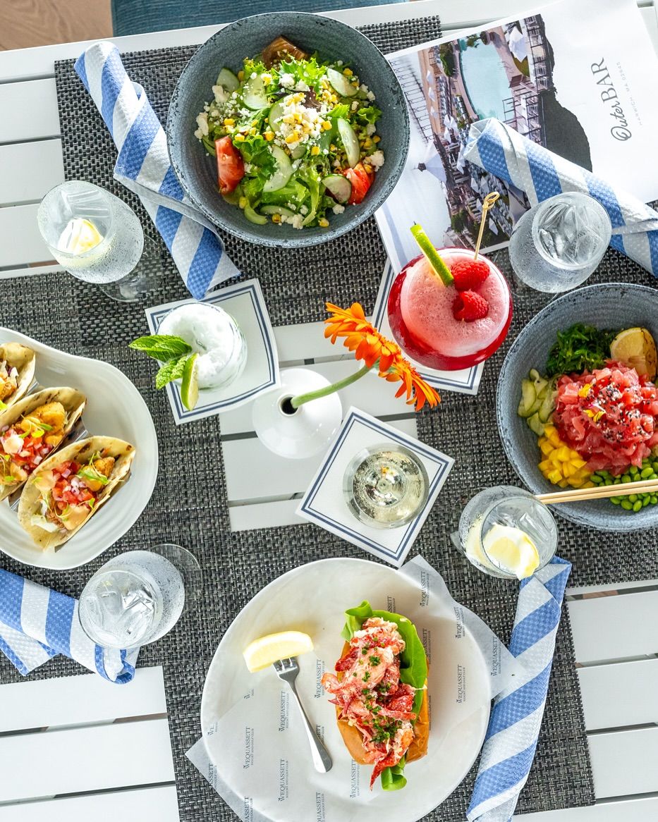 An elegant plated entrée featuring steak topped with bacon-wrapped scallops and served with broccolini and creamy sauce. The dish highlights the refined style of fine dining restaurants. Meals like this showcase the rich seafood and farm flavors of the region.