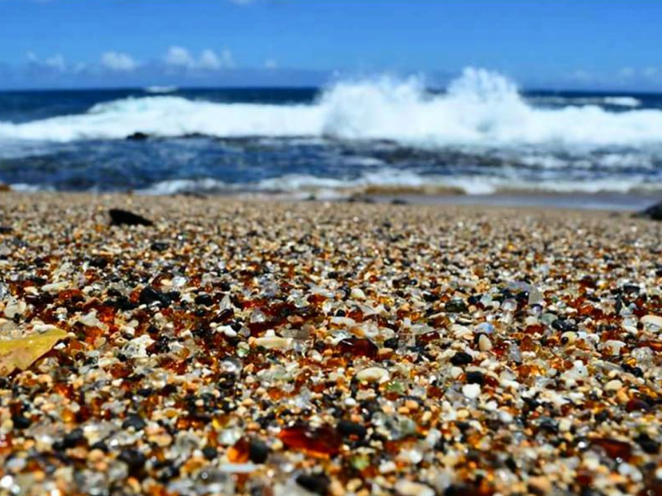 Waves crashing at beach with sea glass