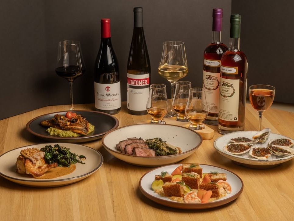 A fine dining table set with wine, whiskey flights, and upscale entrées like lamb, seafood, and oysters. Perfect for a luxury date night or foodie celebration.