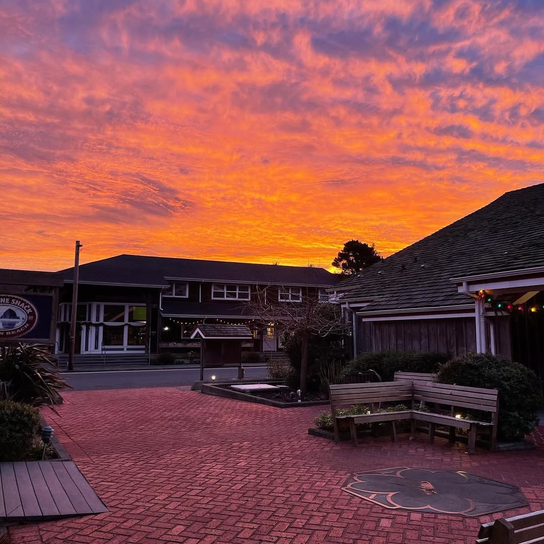 A colorful sunset over the courtyard at Lazy Susan Café in Cannon Beach, with warm lights and a relaxed coastal setting. This inviting spot is popular for casual dining and evening meals while exploring the town