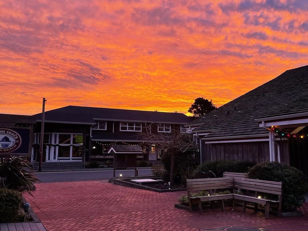 A colorful sunset over the courtyard at Lazy Susan Café in Cannon Beach, with warm lights and a relaxed coastal setting. This inviting spot is popular for casual dining and evening meals while exploring the town