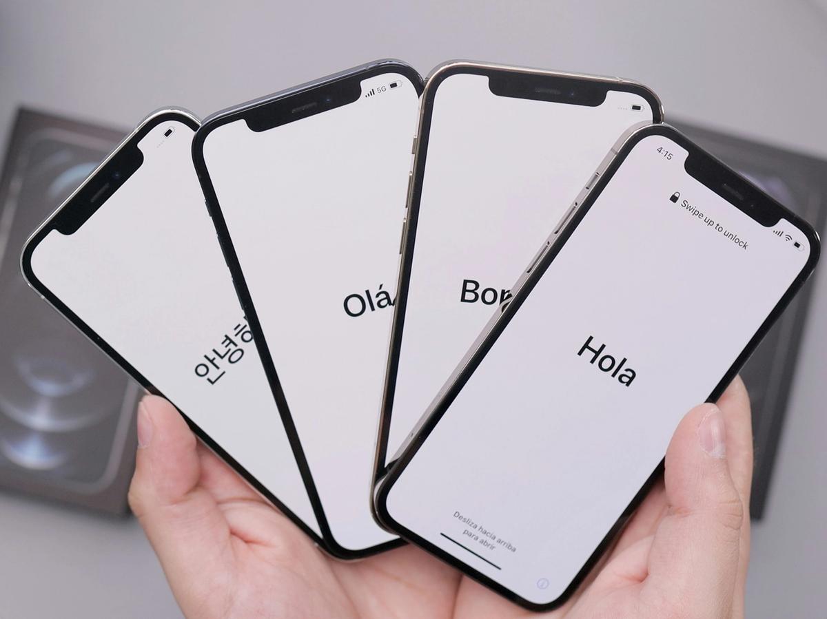 A hand holds four smartphones displaying welcome messages in different languages—Korean, Portuguese, French, and Spanish—on white screens, symbolizing global connectivity and multilingual technology.