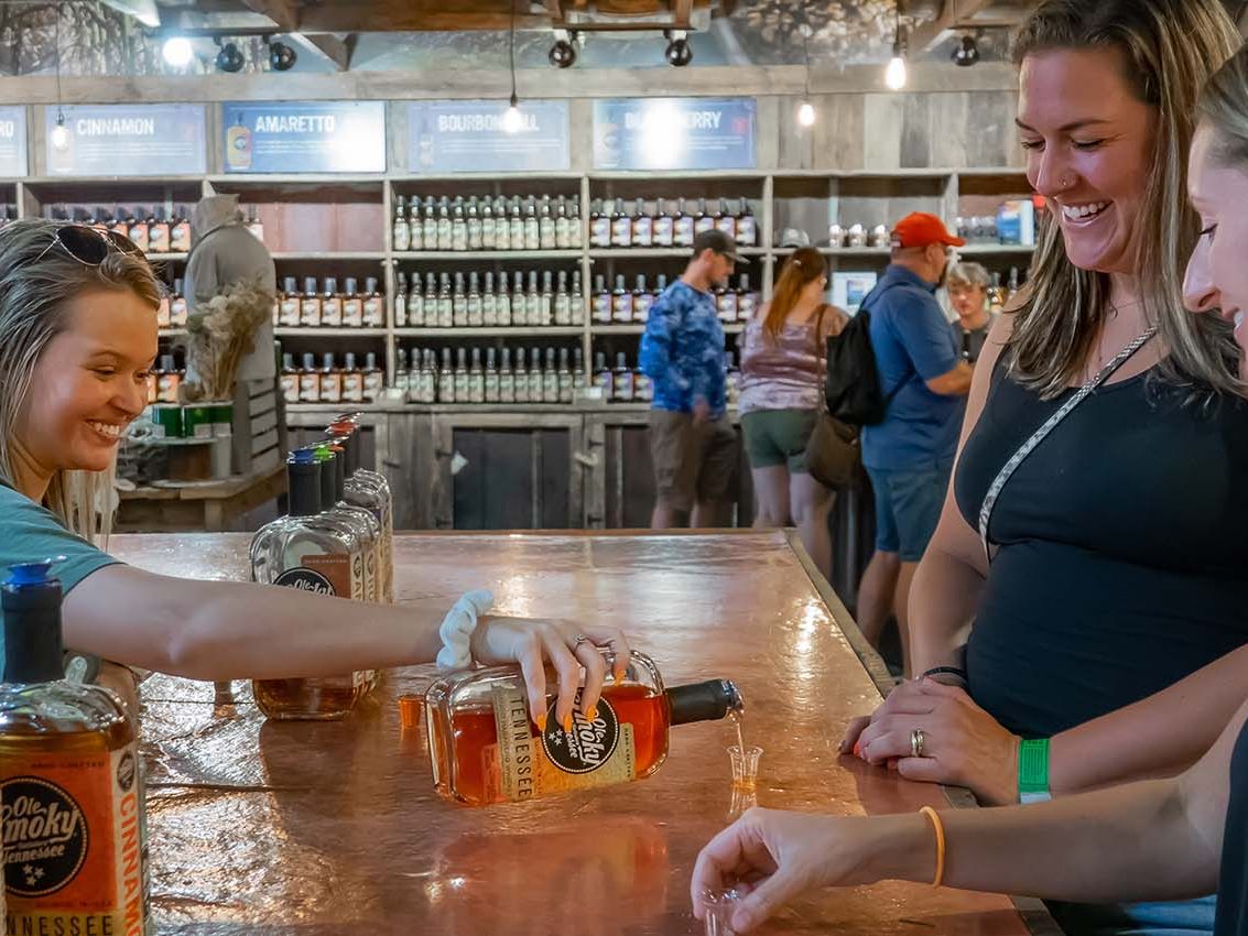 Visitors enjoying a moonshine tasting at Ole Smoky Moonshine Distillery in Gatlinburg, Tennessee. A friendly atmosphere where guests can sample local flavors and experience Smoky Mountain traditions.