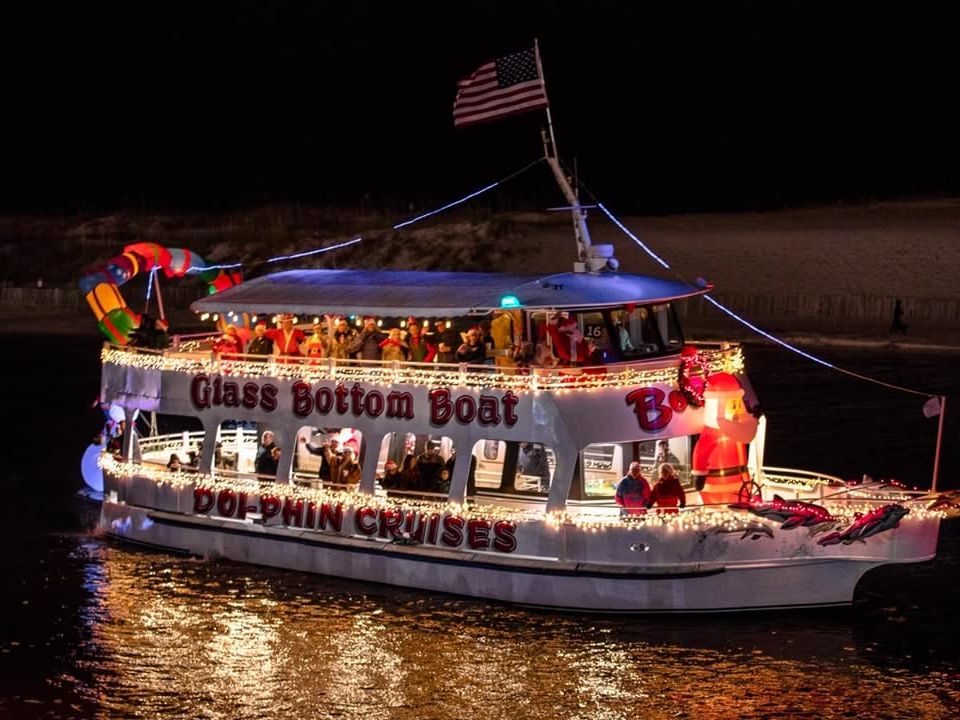 Destin Boat Parade with a festive glass-bottom boat lit up for the holidays and full of smiling passengers.