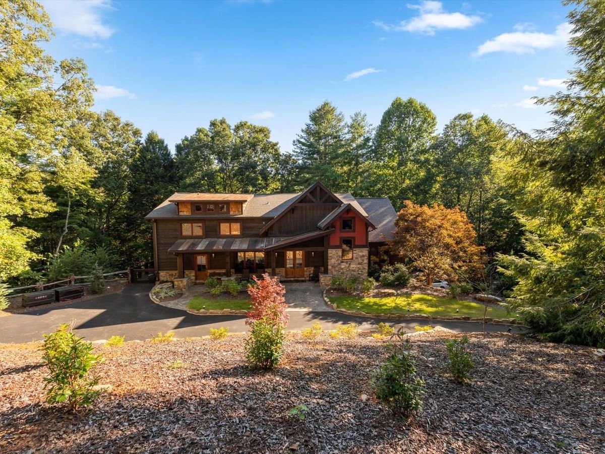 River Joy Lodge sits quietly among tall trees with a warm mix of wood and stone on the exterior. The lush yard and quiet setting make it feel like your own private mountain escape.