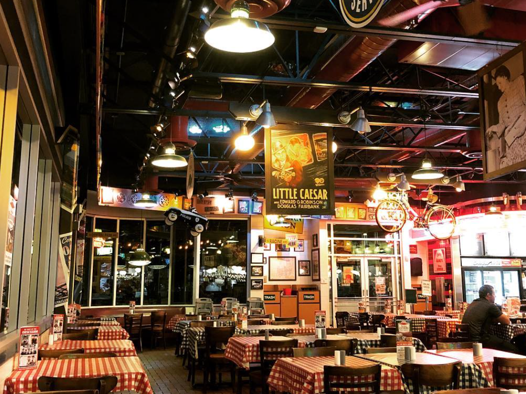 Interior of restaurant with red and white checkers tablecloth and lights hung from ceiling
