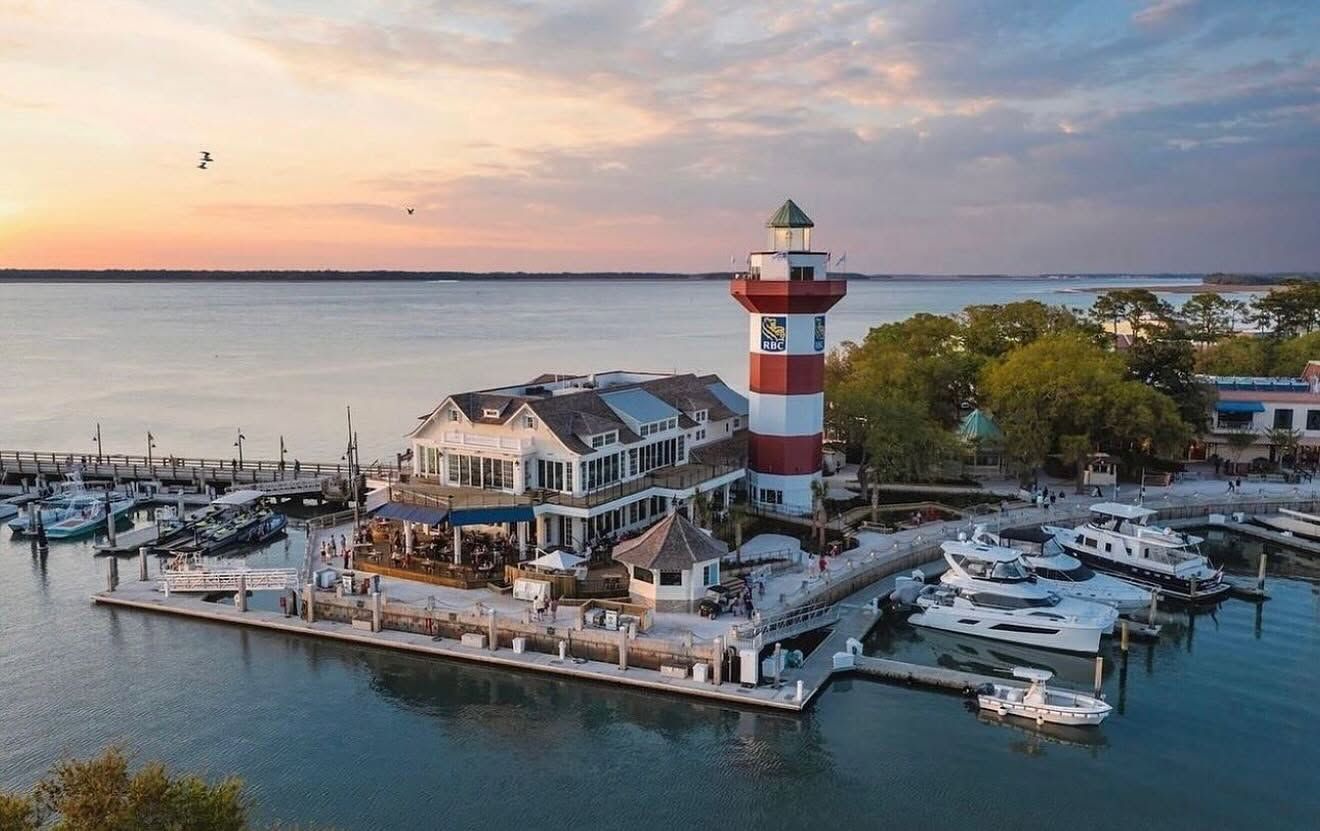 The iconic red-and-white striped lighthouse at Harbour Town Marina in the Sea Pines resort area. It's one of the most photographed spots on the island, overlooking Calibogo Sound. The lighthouse and surrounding marina are famous partly for hosting the RBC Heritage golf tournament (you can see the RBC logo on the tower).