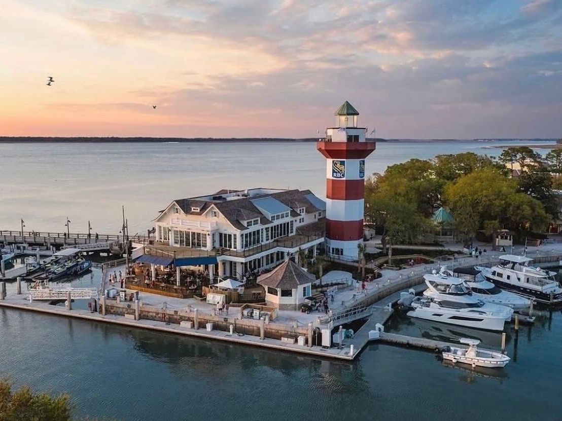 The iconic red-and-white striped lighthouse at Harbour Town Marina in the Sea Pines resort area. It's one of the most photographed spots on the island, overlooking Calibogo Sound. The lighthouse and surrounding marina are famous partly for hosting the RBC Heritage golf tournament (you can see the RBC logo on the tower).