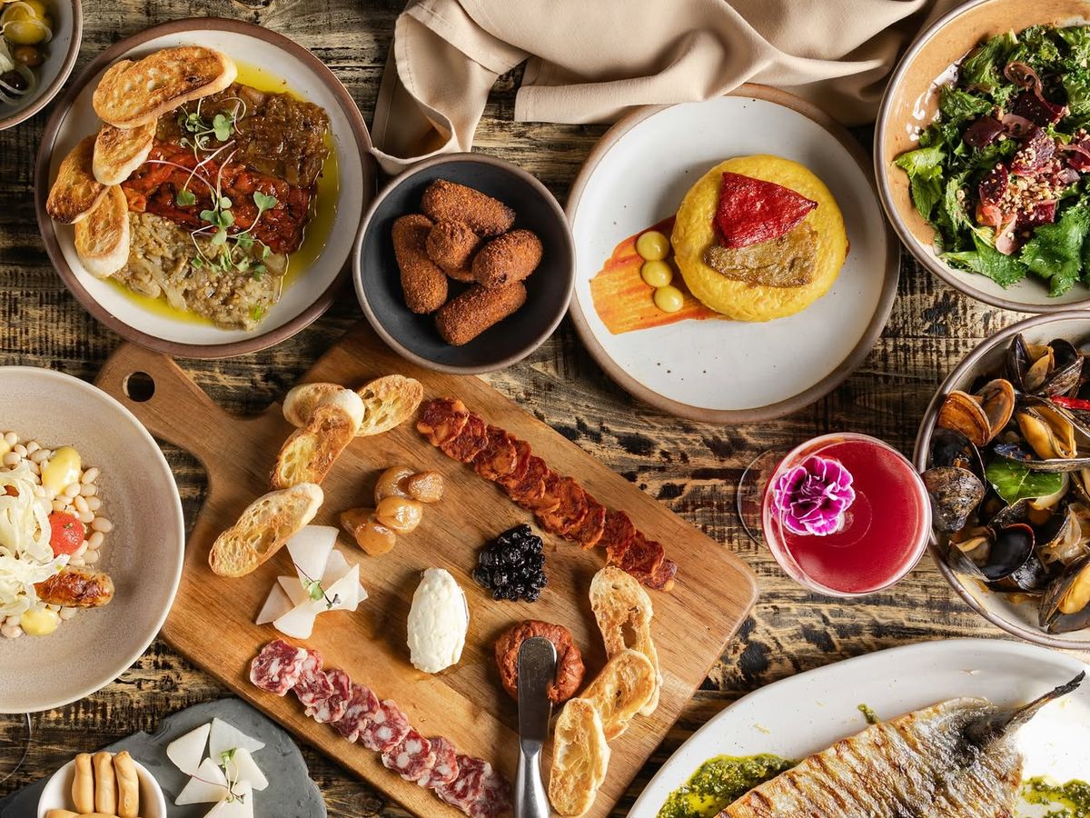 An inviting spread at Cúrate Tapas Bar, showcasing authentic Spanish small plates, artisanal meats, and fresh seafood served in a lively, upscale atmosphere.