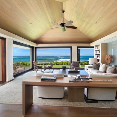 Elegant beachfront living room with high vaulted ceiling, large glass sliding doors