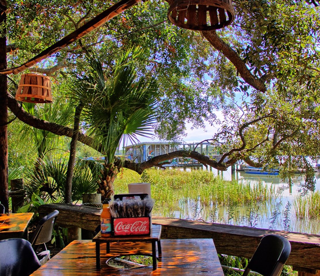 A laid-back outdoor patio at The Original Crab Shack on Tybee Island overlooks the marsh and nearby docks. Wooden tables and coastal decor create a true Georgia seafood shack vibe. It’s a favorite spot for fresh seafood and waterfront dining on Tybee Island.