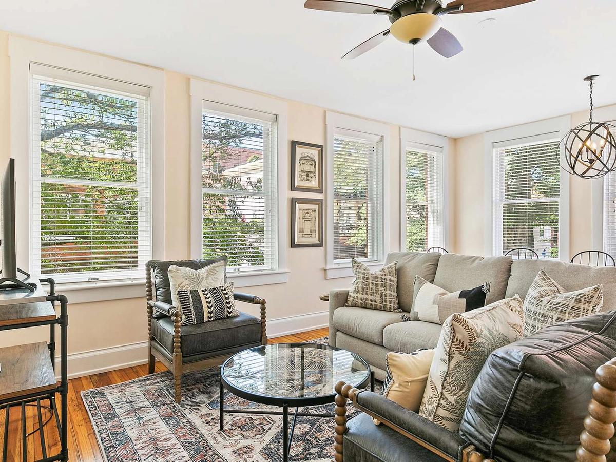 A modern dining area with floor-to-ceiling windows, sleek black furniture, and views of tall pine trees. This open-concept layout blends clean design with natural light for a peaceful dining experience.