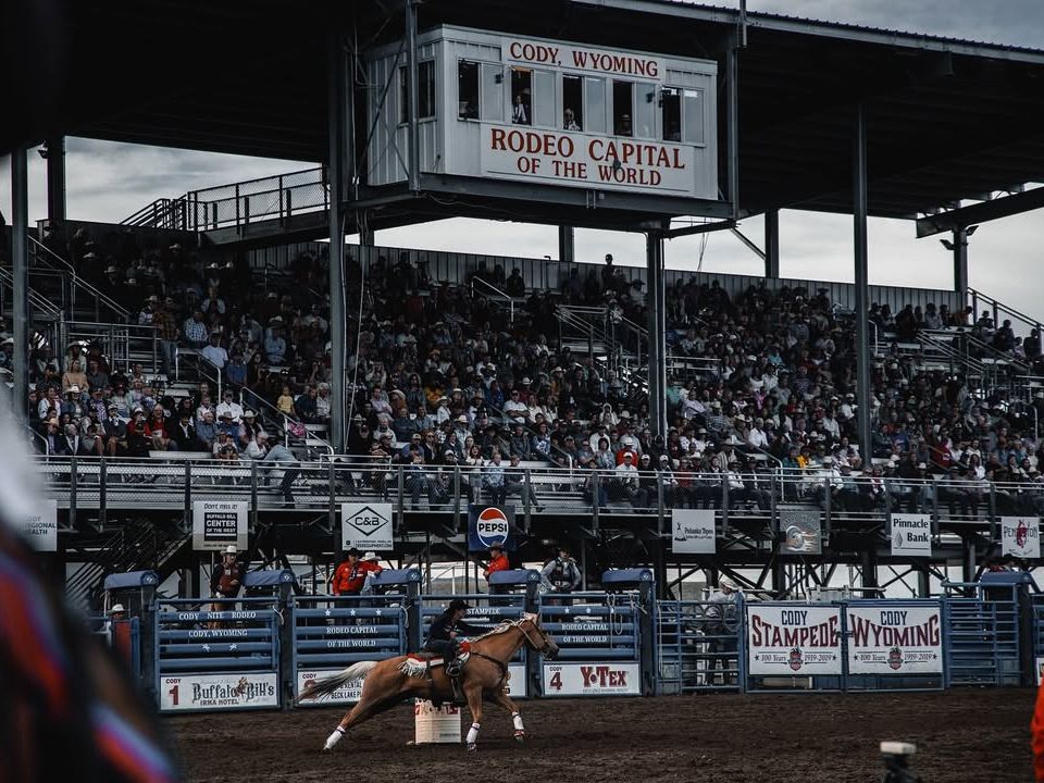 A cowboy competes at the Cody Night Rodeo in Wyoming, known as the Rodeo Capital of the World. With packed stands, thrilling events, and Western tradition, it’s one of the top attractions for visitors in Cody.