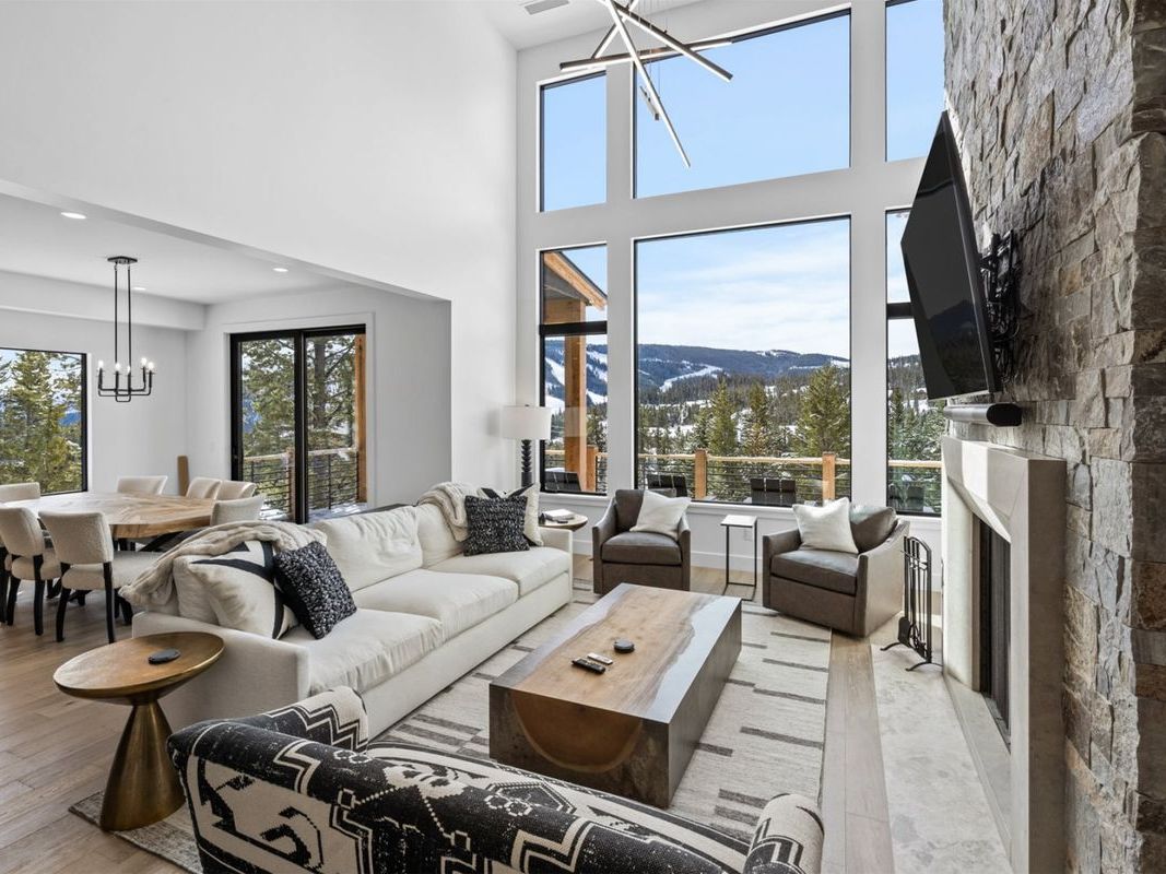 12 Highpoint Drive in Big Sky, MT offers a clean, modern feel with massive windows and snowy peaks in the distance. Relax in the hot tub after skiing or hiking right out your door.