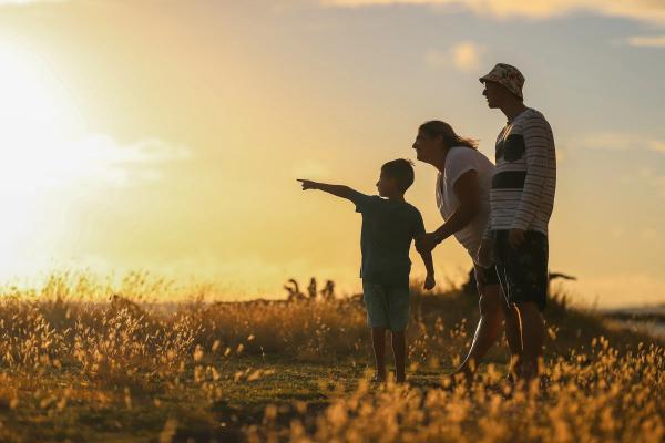 kid pointing at sunset