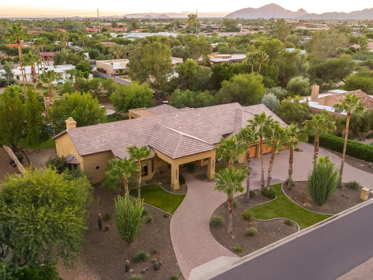 Aerial view of scottsdale rental with palm trees in the front and trees surrounding the backyard